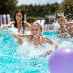 Comment bien profiter d’une piscine quand on a des enfants ? famille qui se baigne dans leur piscine